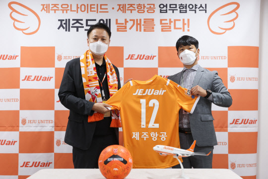 지난 22일 서귀포시 월드컵 경기장 기자회견실에서 진행된 제주항공과 제주유나이티드 업무제휴 협약식에서 유명섭(왼쪽) 제주항공 커머셜본부장과 김현희 제주유나이티드 단장이 기념촬영을 하고 있다. <제주항공 제공>